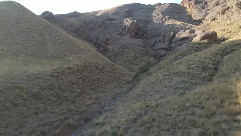 Open dry valley on Chalus Road shows grassy slopes folding into a barren Stock Footage 343907724