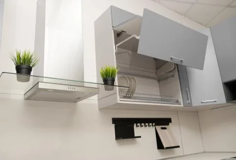 Open drying cupboard with grey facades in scandinavian style next to a fume h Foto stock