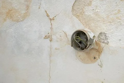 Open electrical junction box with exposed wires on a cracked water damaged .. Stock Photos