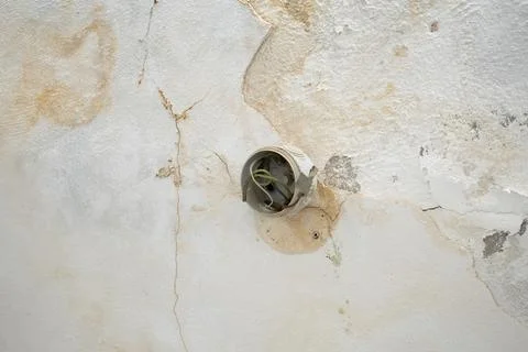 Open electrical junction box with exposed wires on a cracked water damaged .. Stock Photos