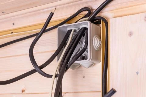 Open electrical junction box with multiple black and white wires protruding i Stock Photos