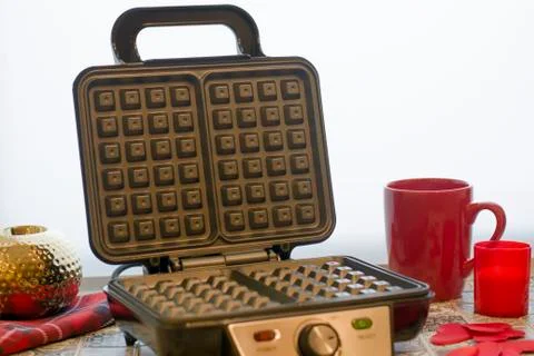 Open electronic waffle-iron. Kitchen view with beautiful red background. Samp Stock Photos