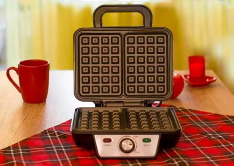 Open electronic waffle-iron. Kitchen view with beautiful red background. Samp Stock Photos