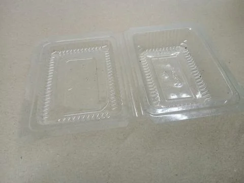 Open empty clear plastic food container on brown background Stock Photos