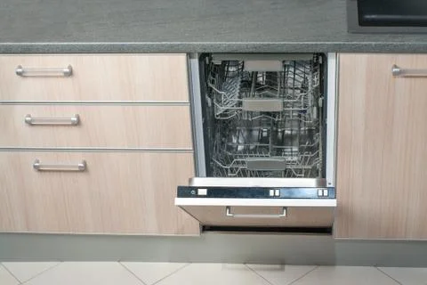 Open empty dishwasher in kitchen. Modern smart electronic housekeeping techno Stock Photos
