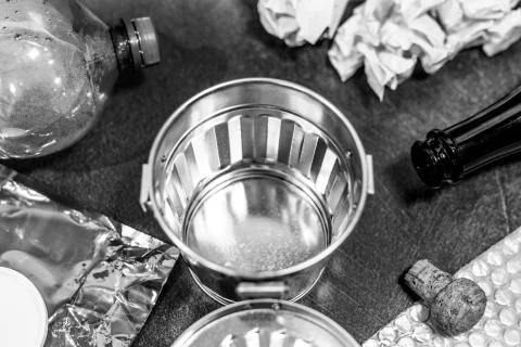 Open empty garbage bin surrounded by reusable waste materials like plastic pa Stock Photos