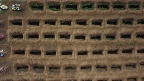 Open empty graves among the green meadow, aerial drone view of empty tombs. Stock Footage 160456419