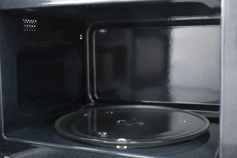 Open empty microwave oven, closeup. Inside view Stock Photos