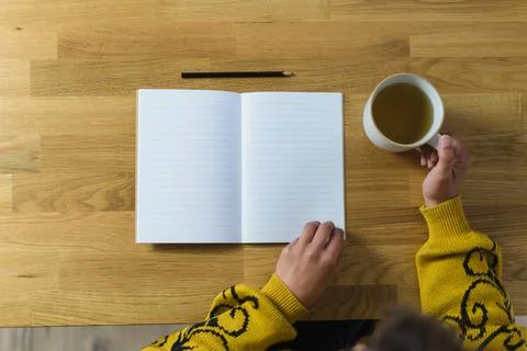 Open empty notebook and pencil, woman holding a mug with tea Stock Photos
