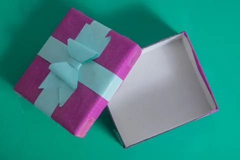 Open empty pink gift box with bow on vibrant green background Stock Photos