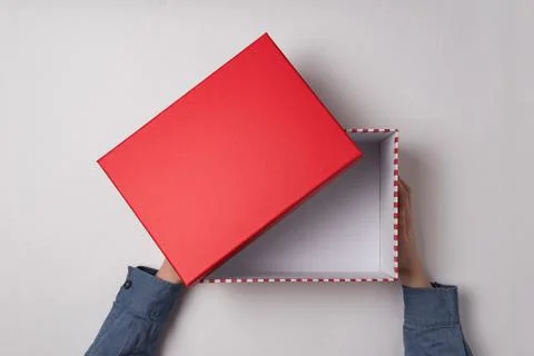 Open empty red box in children's hands on white background. Top view. 스톡 사진