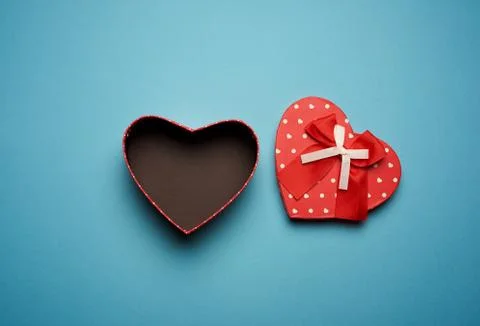 Open empty red cardboard box in the form of a heart on a light blue backgroun Stock Photos