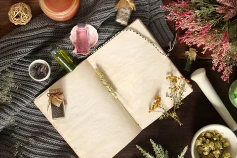 An open empty vintage notebook surrounded by herbs, alchemy appliances, potio Stock Photos