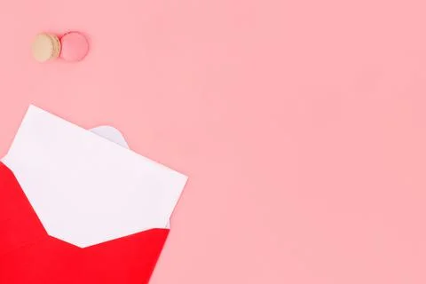 Open envelope with empty blank, and macaroons on pink background Space for te Stock Photos