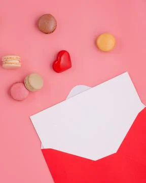 Open envelope with empty blank, heart  and macaroons on pink background Stock Photos