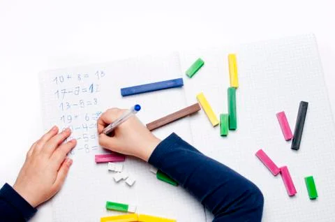 Open exercise book with colored plastic number rods on white background. Foto stock
