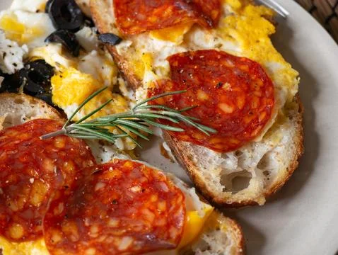 Open face breakfast toast with fried egg chorizo sausage feta cheese black .. Foto stock