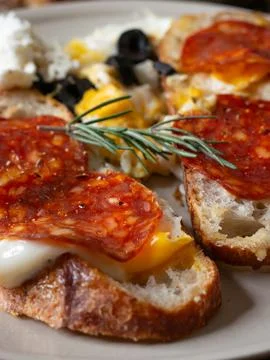 Open face breakfast toast with fried egg chorizo sausage feta cheese black .. Stock-Fotos