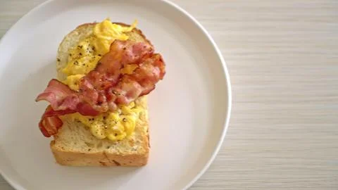 Open-faced breakfast sandwich with bacon, eggs, and toast Stock Photos