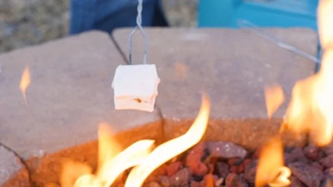 Open fire and marshmallow placed on the end of a skewer Stock-Footage 106625131
