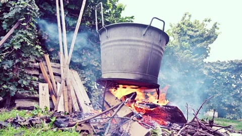 Open fire burning under an old pot, scene taken outside Stock Footage 232798187