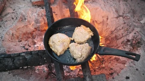Open Fire Cooking: Chicken in a Pan Over Campfire Stock Footage 284673724