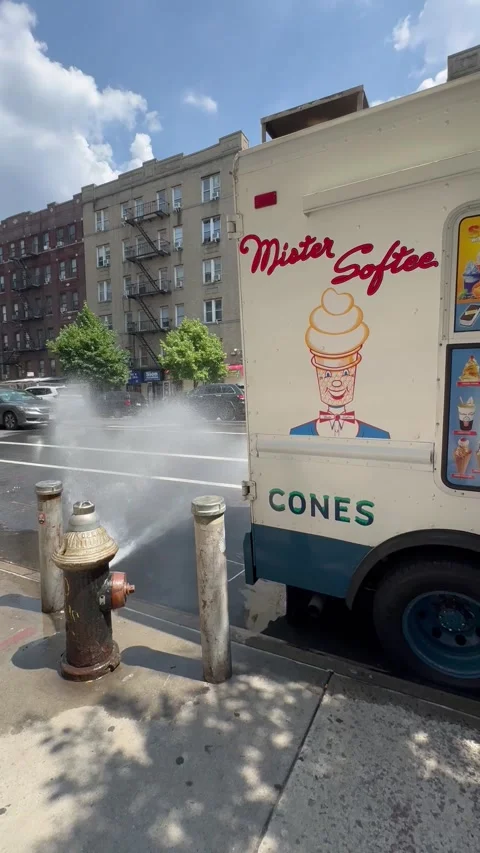 Open fire hydrant next to a Mister Softee ice cream truck in New York City Stock Footage 309947931