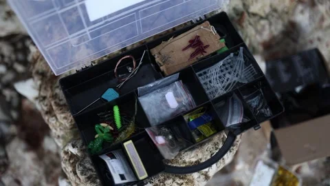Open fishing tackle box with hooks worms lures and accessories ready for fishing Video stock 341622310