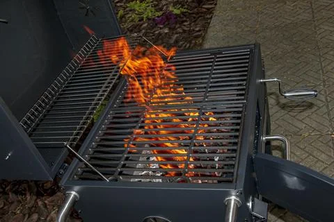 Open Flame Burning Through Barbecue Grate on Outdoor Charcoal Grill Stock Photos