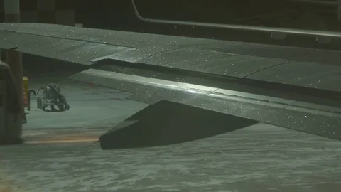 Open the flap on the icy wing of the plane. Winter, night. A passenger bus passe Stock Footage 78727900