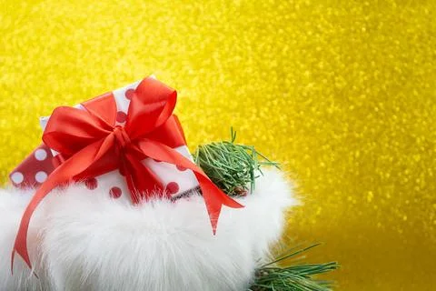Open fluffy bag with gift box with polka dot and red bow and fir branches Stock Photos