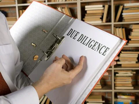 Open folder and documents about Due diligence. 스톡 사진