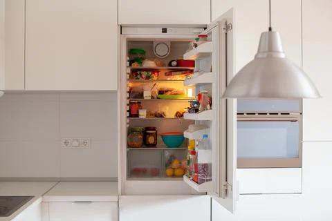Open fridge in the kitchen. Stock Photos