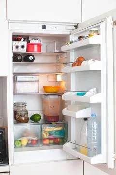 Open fridge in the kitchen. Stock Photos
