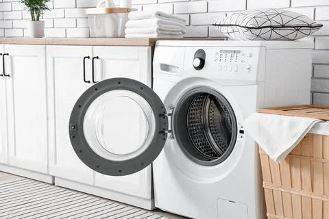 Open front-loading washing machine in modern laundry room Stock Photos