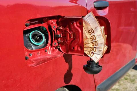 Open fuel tank of a car with a bundle of fifty euro banknotes in the lid Stock Photos