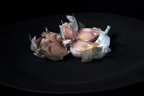 Open garlic on black background table Stock Photos
