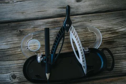 Open geometry compass set with a short black pencil stored. Stock Photos