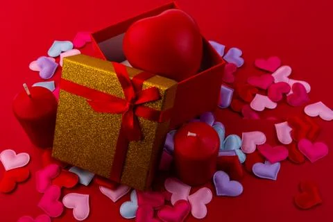 Open gift box with a heart inside. Little hearts are scattered around. Stock Photos