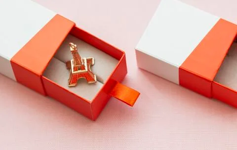 In the open gift box lies the eiffel tower on a pink background Stock Photos
