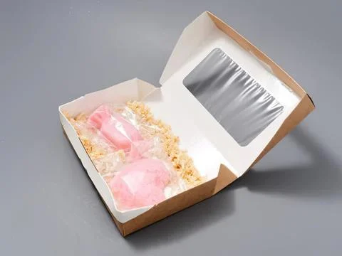Open gift box with pink roses and shredded paper inside Stock Photos