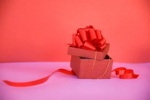 Open Gift Box red copy space on pink / red present box with red ribbon bow fo Foto stock