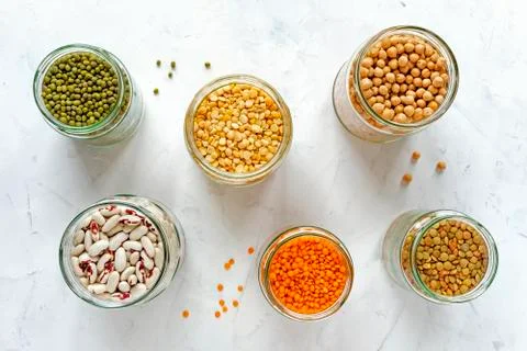 Open glass jars full of assorted dried legumes Stock Photos
