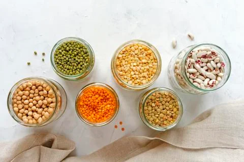 Open glass jars full of assorted dried legumes Stock Photos