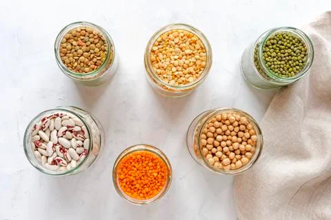 Open glass jars full of assorted dried legumes Stock Photos