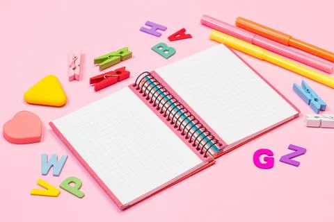 Open graph notebook and school utensils on a pink background Stock Photos