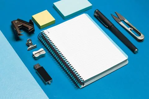 Open graph paper notebook and student utensils on a blue background Stock Photos