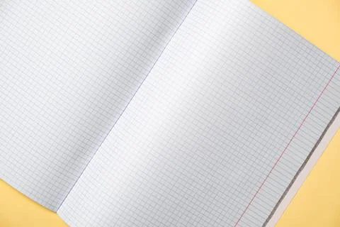 An open graph ruled notebook with graph paper lies on a yellow surface, the.. Stock Photos