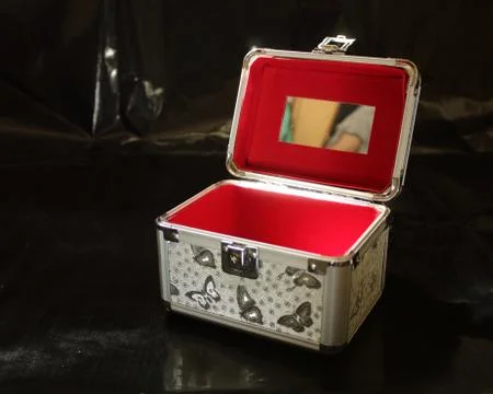 Open gray red makeup case on a black background Stock Photos