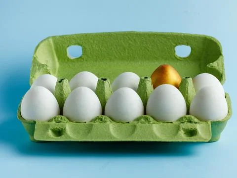 Open green box Easter chicken eggs on blue background. One egg different colo Stock Photos